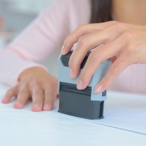 Close up image of notary stamping paperwork